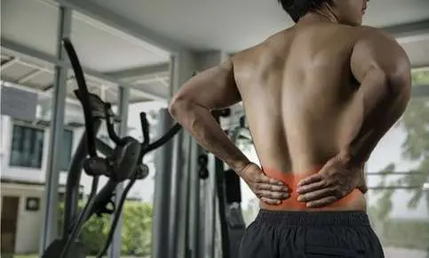 Fitness enthusiast experiencing backache indoors