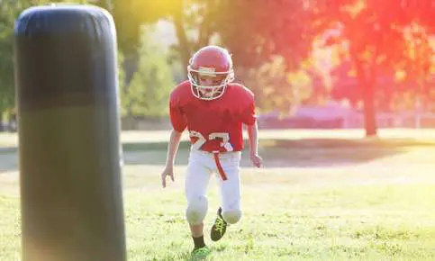 Child wearing football gear running