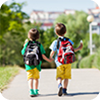 Two boys walking towards school together.