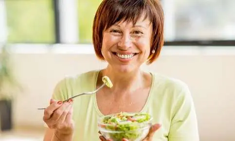 Happy woman with a salad bowl