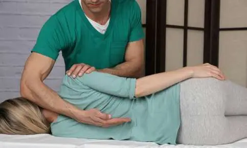 Chiropractor adjusting patient's back