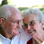 Elderly couple smiling and embracing outdoors