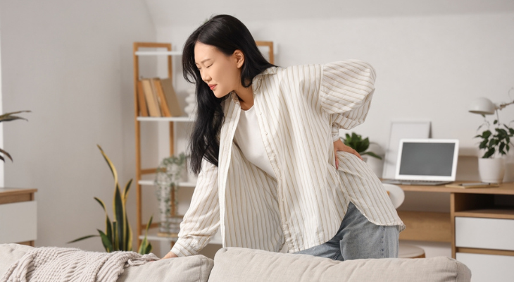 Woman holding her back in discomfort