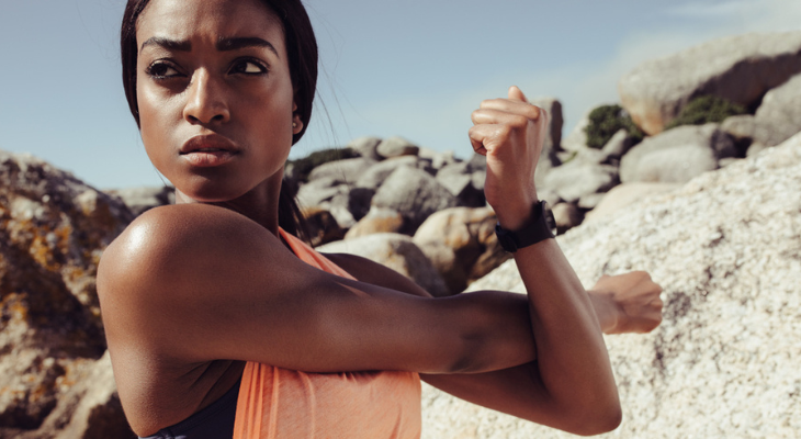 Fitness enthusiast exercising among large rocks