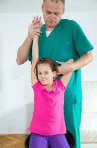 Healthcare professional helping child stretch arm