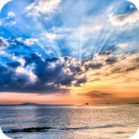 Sunset over calm ocean with clouds