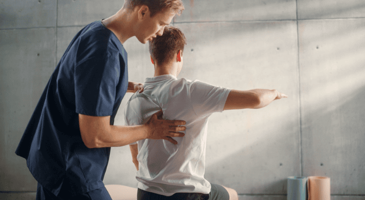 Man receiving physical therapy guidance in clinic