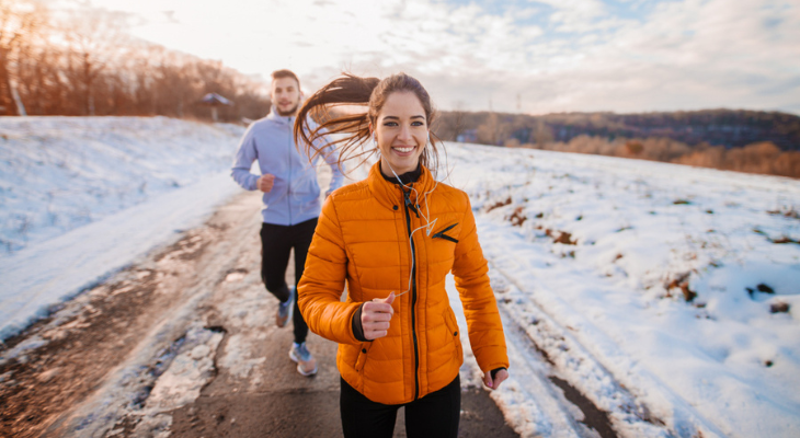 Smiling runners exercising in winter landscape