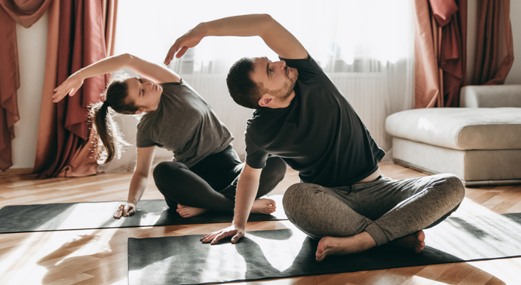 Couple practicing yoga at home