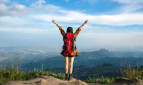 Woman with backpack on cliff