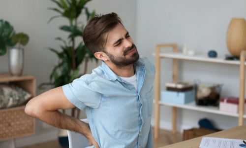 Man experiencing back pain in office