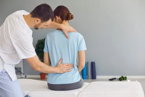 Chiropractor adjusting woman's back