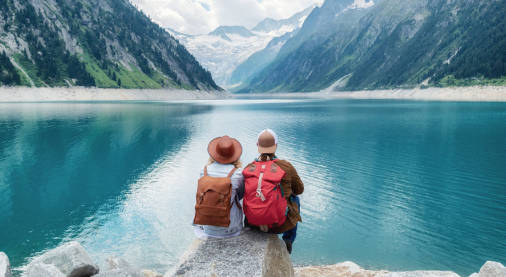 Two hikers overlooking serene lake