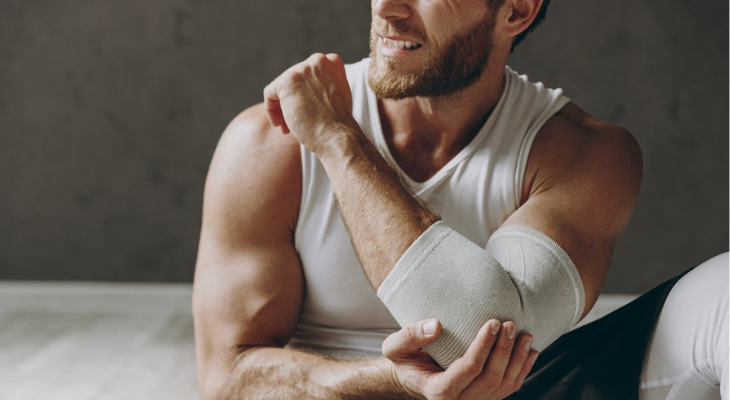 Athletic man adjusting elbow support