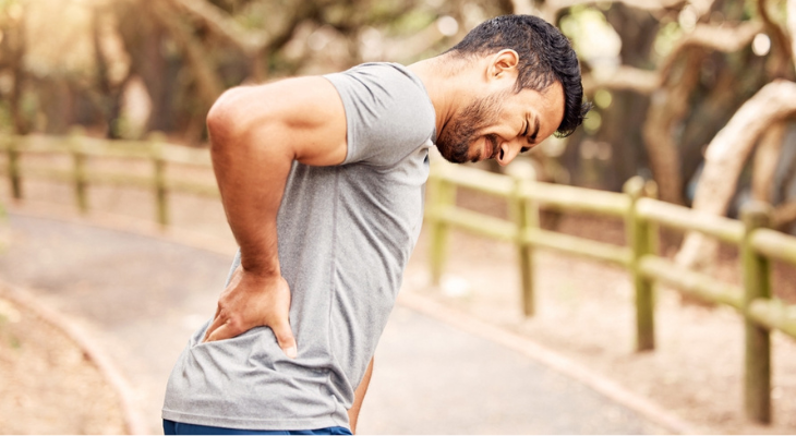 Man experiencing back pain outdoors