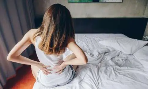 Morning backache in bedroom setting.
