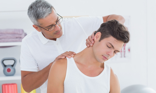 Chiropractor treating a young man's neck