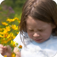 Young child reacting to flowers outdoors
