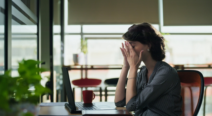 Woman overwhelmed at computer table