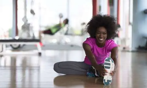 Smiling woman doing a seated stretch