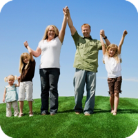 Family holding hands on grassy hill