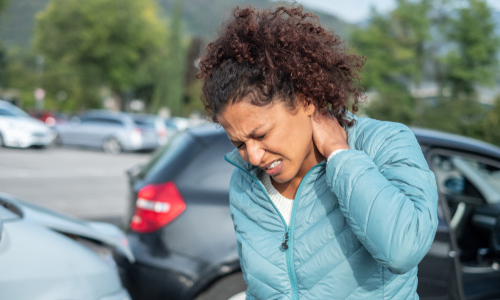 Injured woman standing by damaged cars