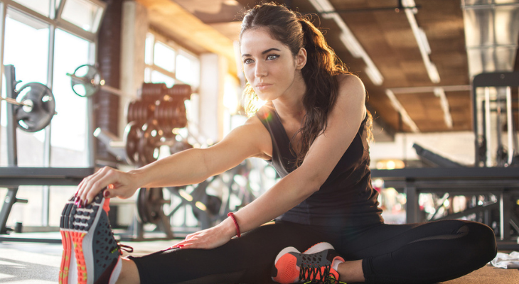 Woman stretching on gym floor