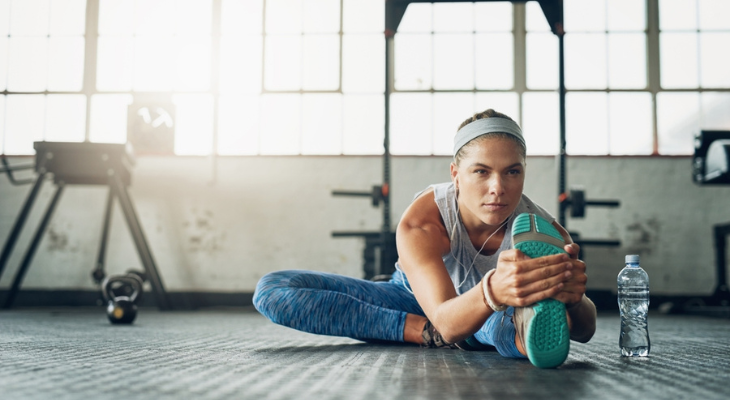 Athlete doing floor stretches in sunlight