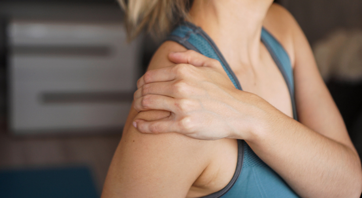 Woman holding shoulder in pain
