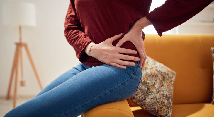 Woman holding hip in discomfort