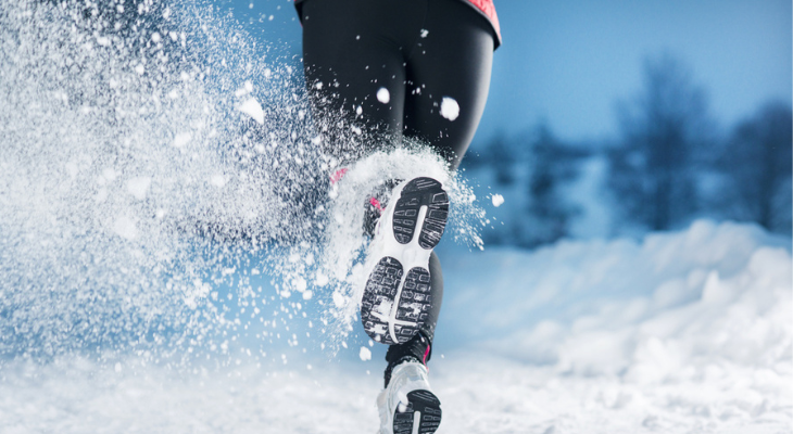 Runner's feet kicking up snow