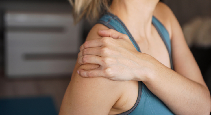 Woman holding her shoulder in pain
