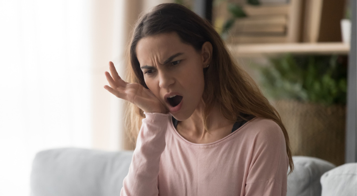 Woman yawning on a couch