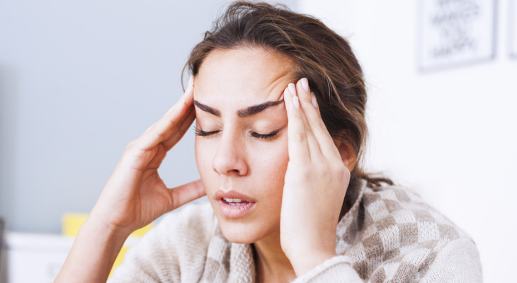 Female experiencing tension headache indoors