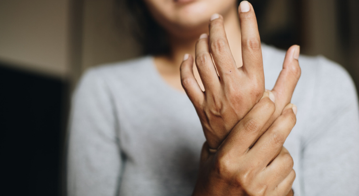 Person holding wrist in discomfort