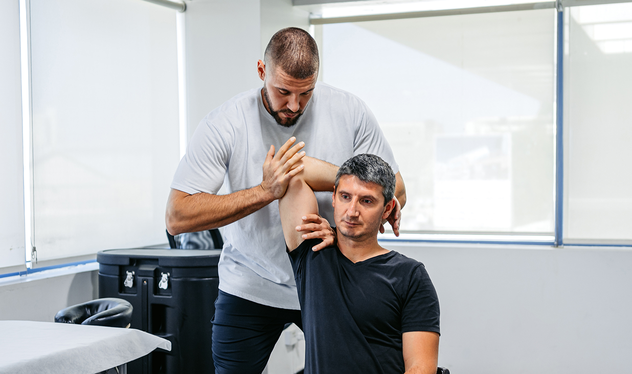 Man receiving shoulder treatment in clinic