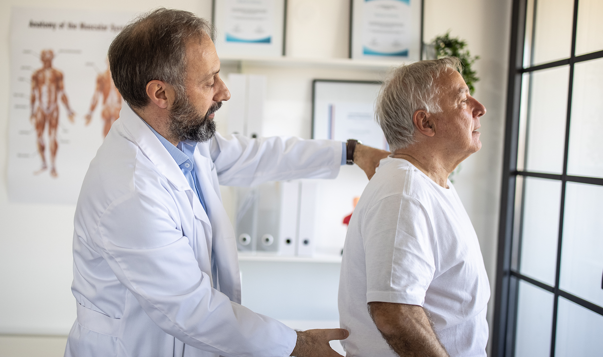 Medical professional assessing senior's back health