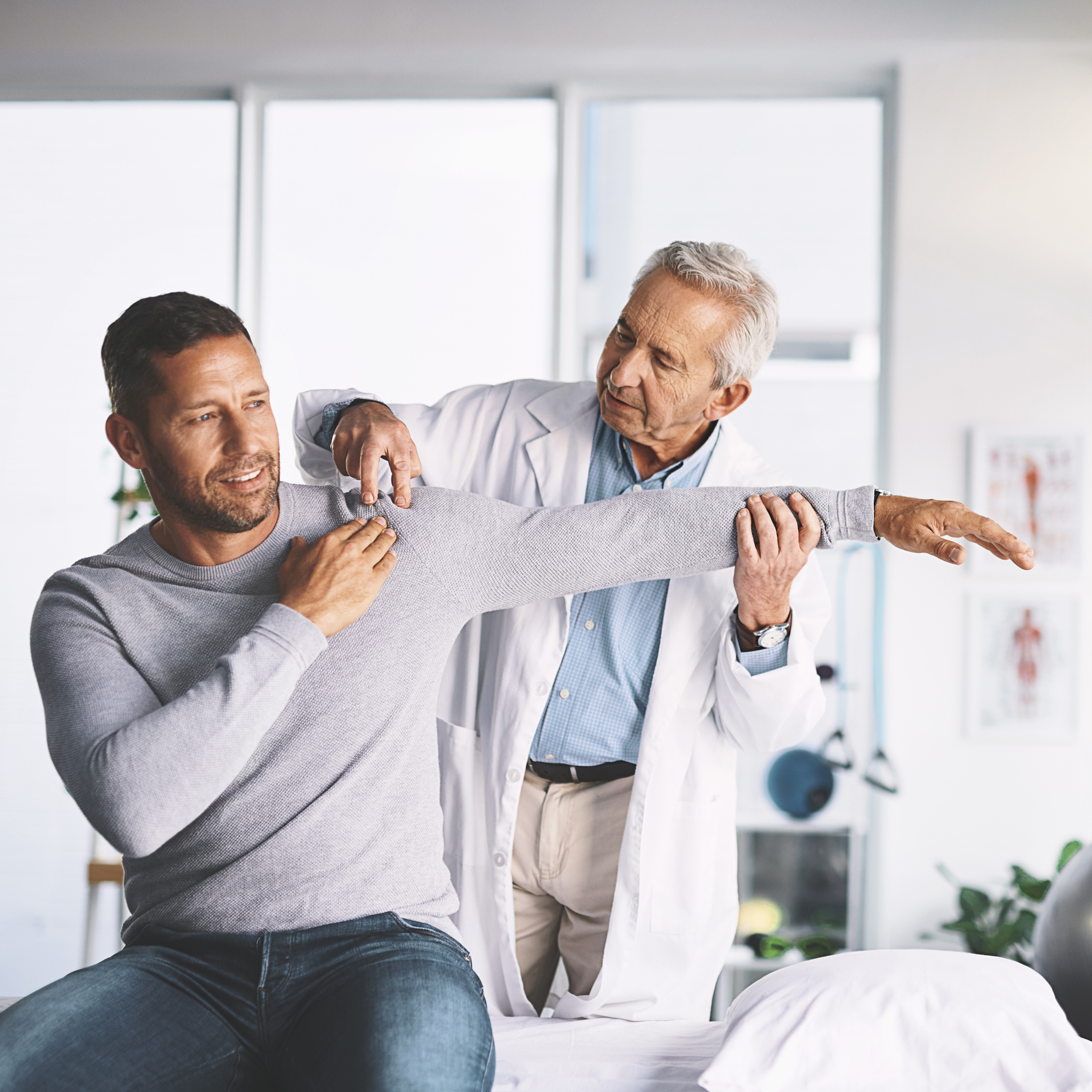Doctor examining patient's shoulder mobility