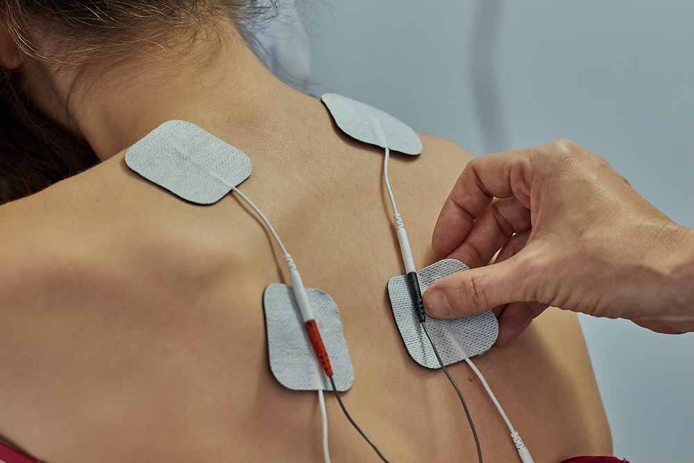 Hand adjusting electrode pads on skin