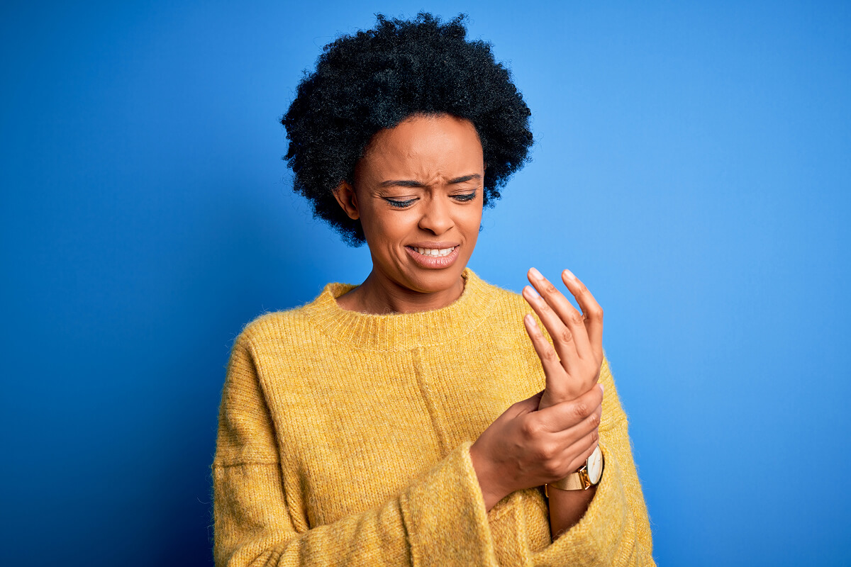 Woman in yellow sweater, wrist pain