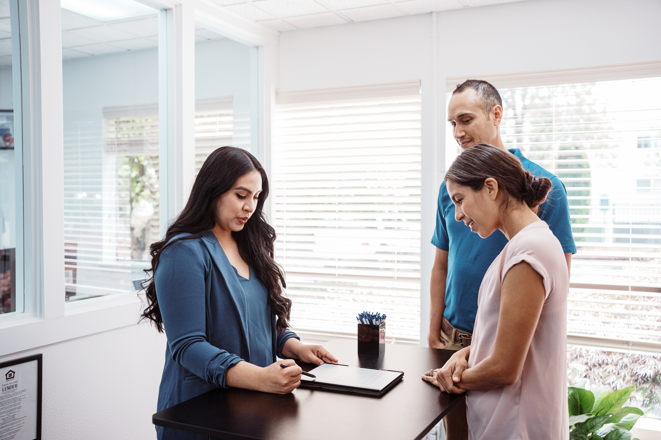 Three people gathered around office table