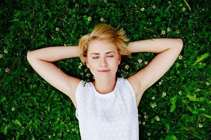 Woman relaxing on green grass