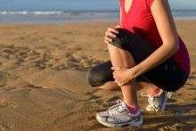 Woman kneeling on beach sand