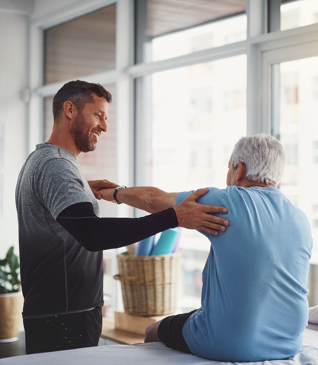 Physical therapist assisting elderly patient