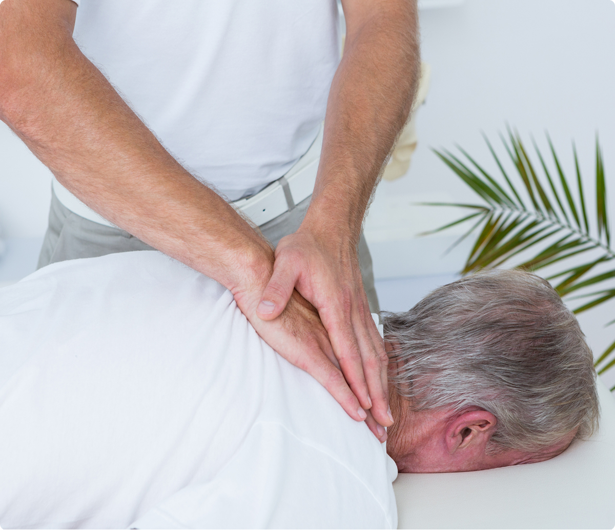 Massage therapy on elderly man's back