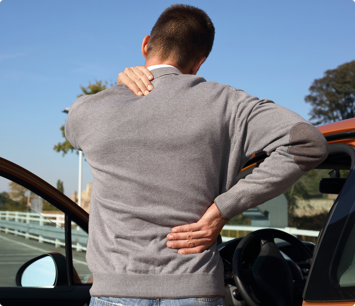 Person holding back and neck outdoors