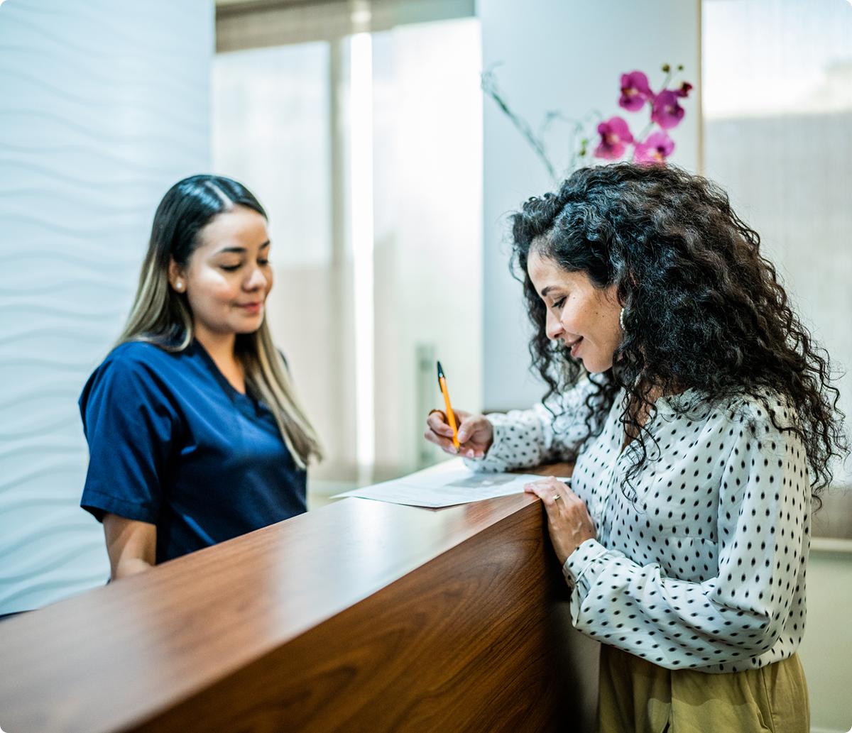 Woman completing paperwork at front desk