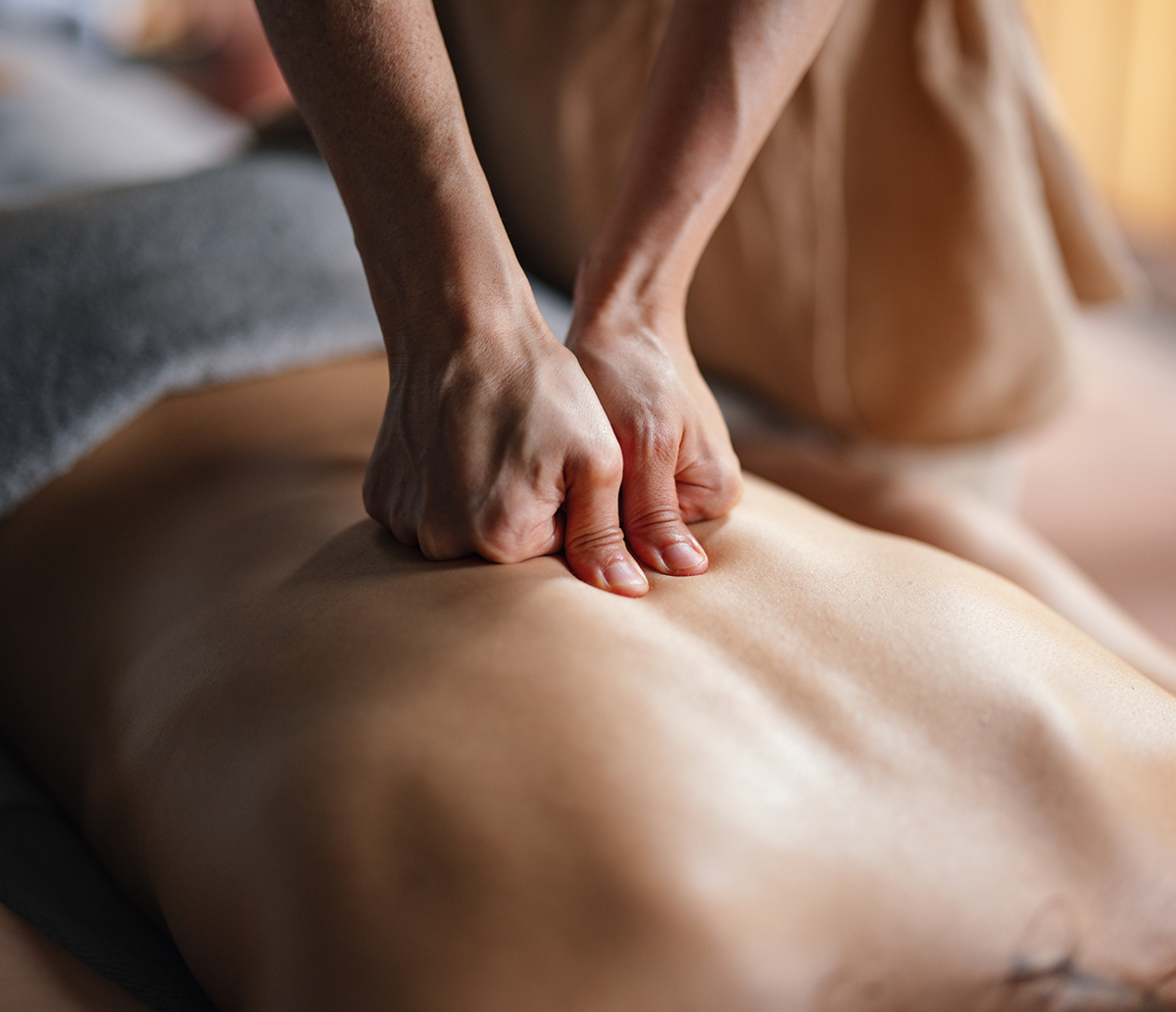 Hands applying massage on back