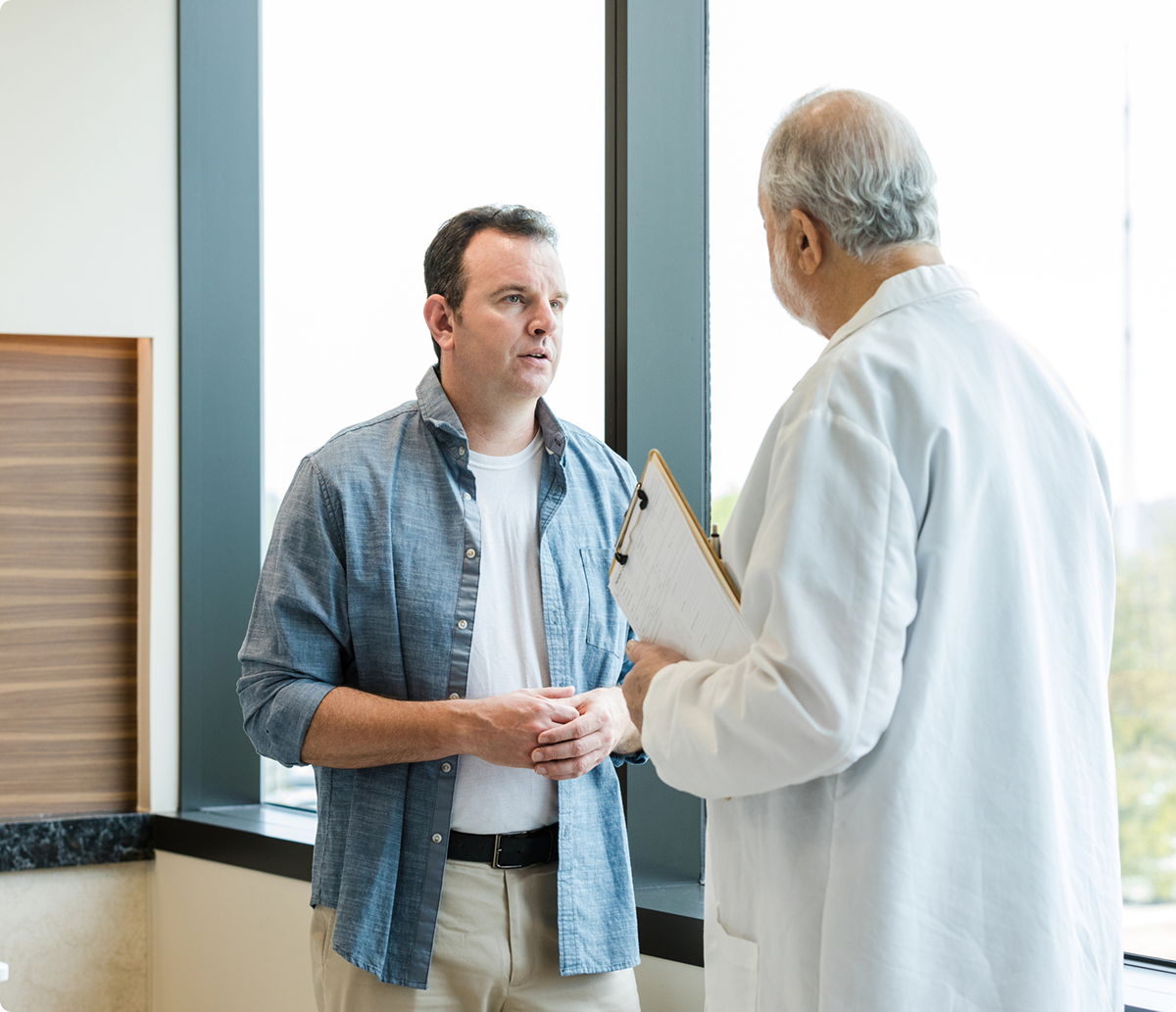 Doctor holding clipboard during conversation