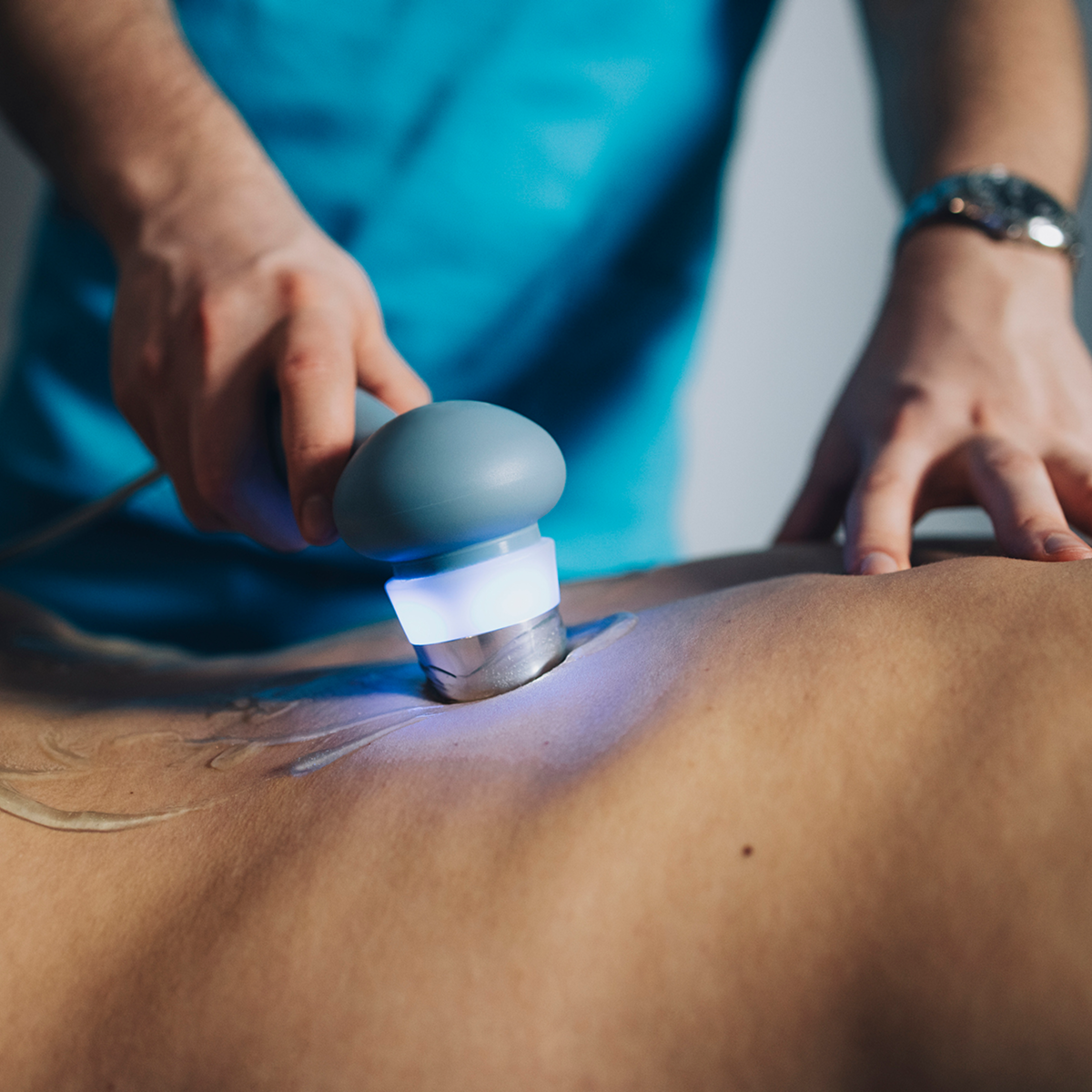 Hands holding massage tool on skin